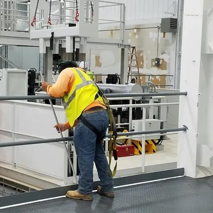 Worker in a yellow safety vest during industrial equipment cleaning services in Greenville, SC.