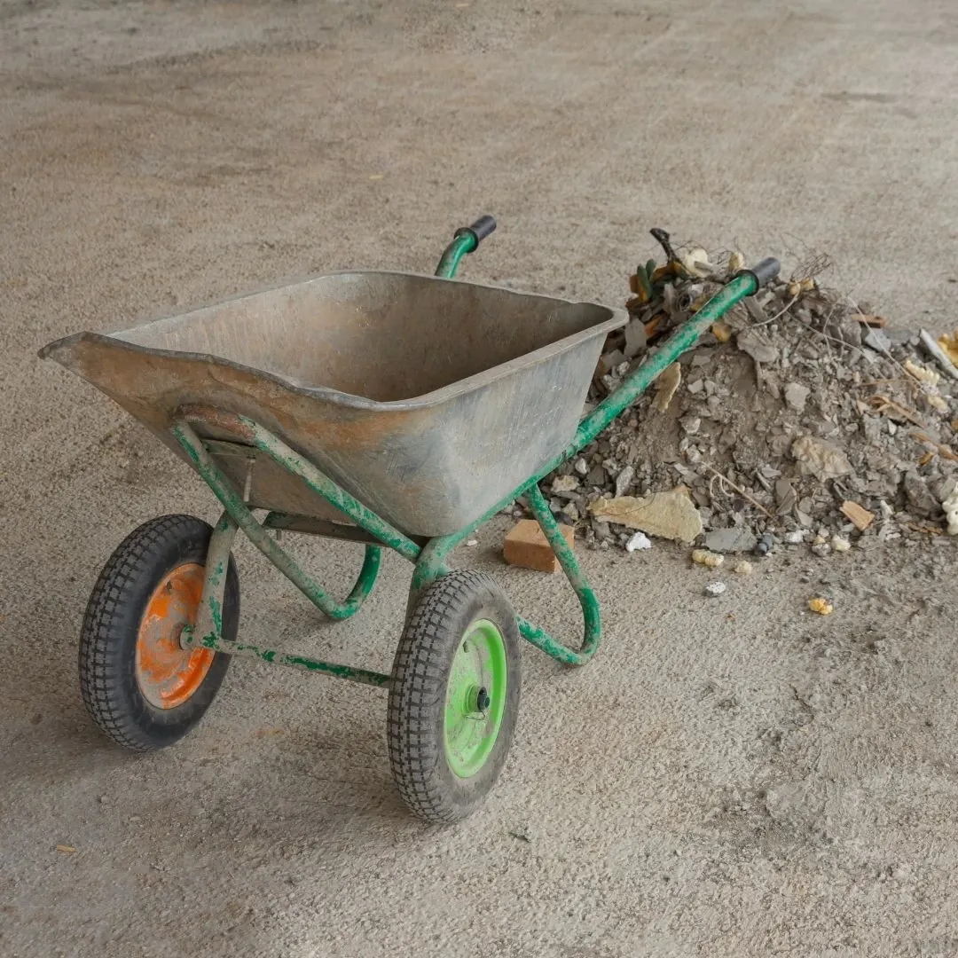 Wheelbarrow beside a pile of rubble and drywall scraps awaiting post-construction cleaning in Greenville, SC Wheelbarrow beside a pile of rubble and drywall scraps awaiting post-construction cleaning in Greenville, SC